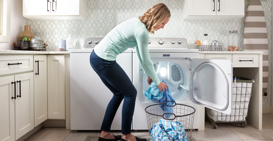 a woman pulling clothes out of the dryer